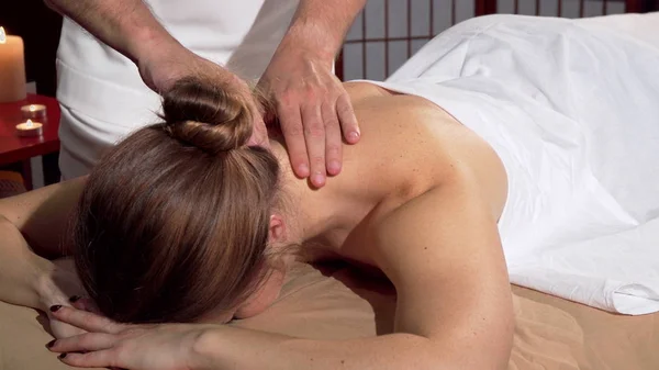 Masajista profesional haciendo relajante masaje de espalda para cliente femenino — Foto de Stock