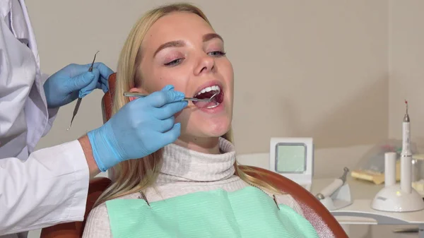 Junge Frau lässt sich von professionellem Zahnarzt untersuchen — Stockfoto