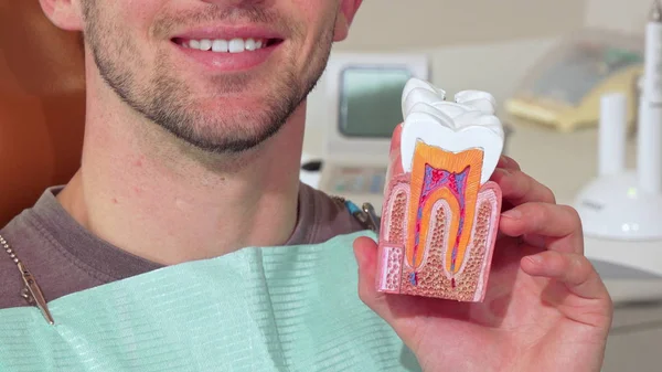Mann mit weißen gesunden Zähnen lächelt und hält Zahnschimmel in der Klinik — Stockfoto