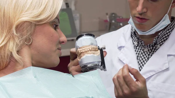 在他的诊所工作的男牙医, 向病人展示牙科霉菌 — 图库照片