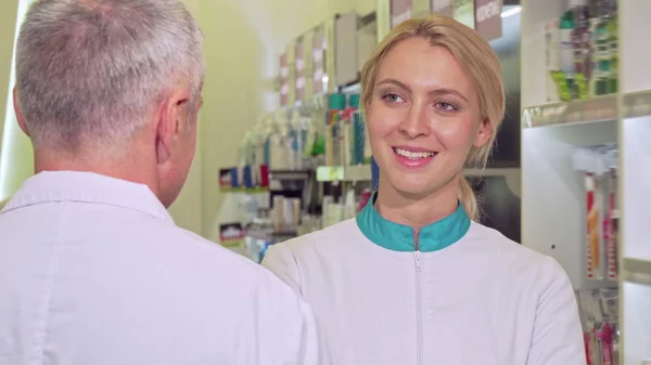 Krásné ženské chemik radostně usmívat, mluvit s její starší kolega — Stock fotografie