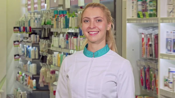 Alegre farmacéutica cruzando los brazos, posando orgullosa en su farmacia — Foto de Stock