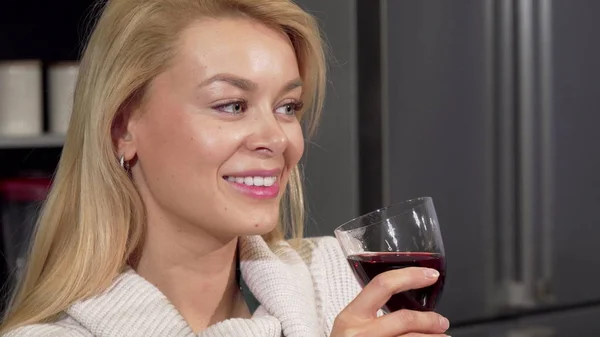 Szczęśliwy piękna kobieta uśmiechając się do kamery, ciesząc się picia wina w domu — Zdjęcie stockowe