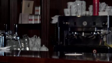 Gülümseyerek, bardak bira tezgahın üzerine koyarak tanınmaz barmen