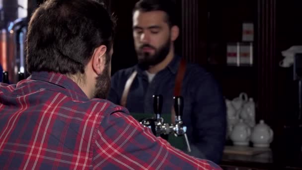 Cliente masculino sonriendo a la cámara, tomando deliciosa cerveza en el pub — Vídeos de Stock