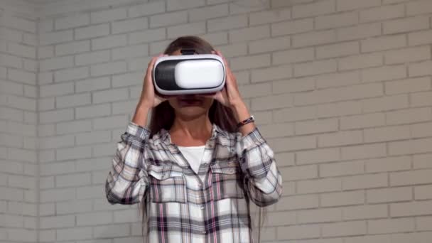 Mujer joven atractiva mirando emocionada, usando gafas de realidad virtual — Vídeos de Stock