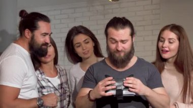 Arkadaşları ile sanal gerçeklik gözlük kullanan sakallı adam