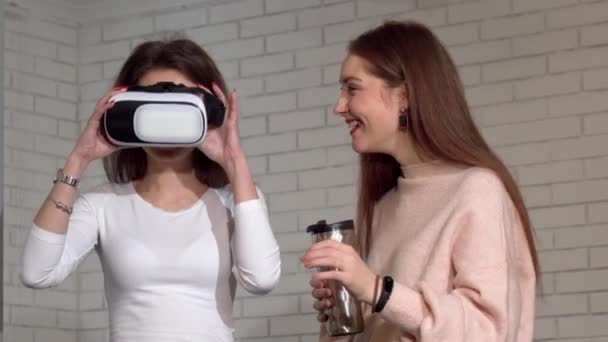 Two lovely female friends using 3d virtual reality goggles together — Stock Video