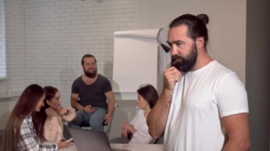 Olgun yakışıklı sakallı işadamı düşünceli kameraya gülümseyen