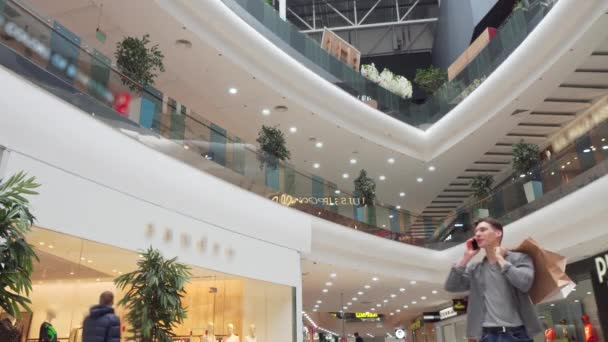 Joven hablando por teléfono en el centro comercial — Vídeo de stock