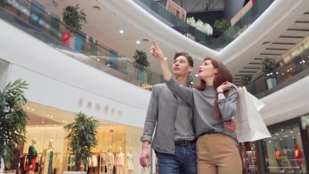 Low angle shot of a young couple looking around at the shopping mall — Stock Video