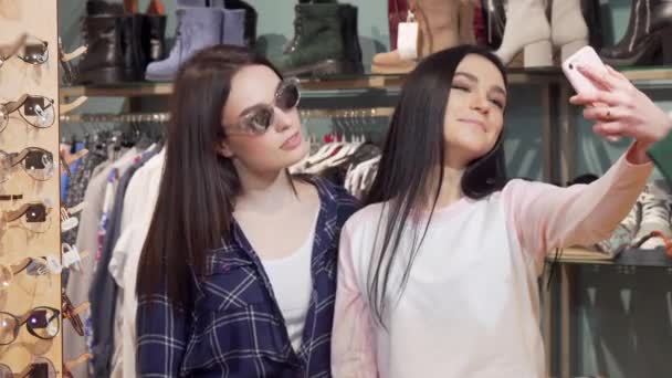 Ami féminin joyeux prenant selfies avec téléphone intelligent au magasin de vêtements — Video