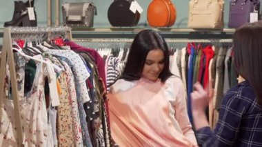 Giyim butiğinde birlikte elbise alışverişinin keyfini çıkaran kadın arkadaşlar