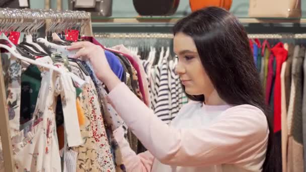 Žena, která vypadá šokovaně cenou za šaty v obchodě s oděvy — Stock video