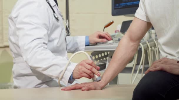 Bilek kemiklerini ultrason tarayıcısı kullanarak doktor tarafından kontrol yaptıran adam — Stok video