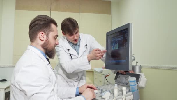 Dos doctores discutiendo los resultados de la ecografía de un paciente — Vídeos de Stock