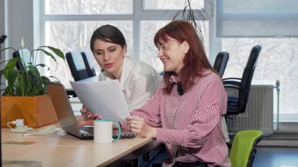 Duas mulheres de negócios a tratar da papelada juntas no escritório — Vídeo de Stock