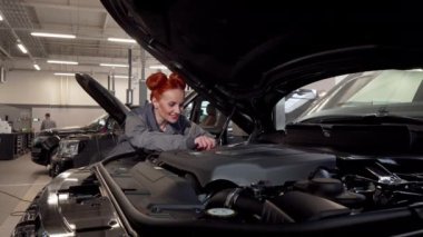 Çekici kadın araba tamircisi kamera gülümseyen, garajda çalışma