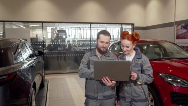 Két autómechanika segítségével laptop, dolgozó a garázsban — Stock videók