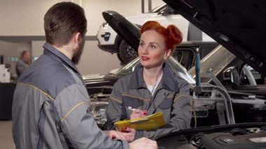 Güzel kadın tamirci garaj bir meslektaşım konuşurken, notlar almak