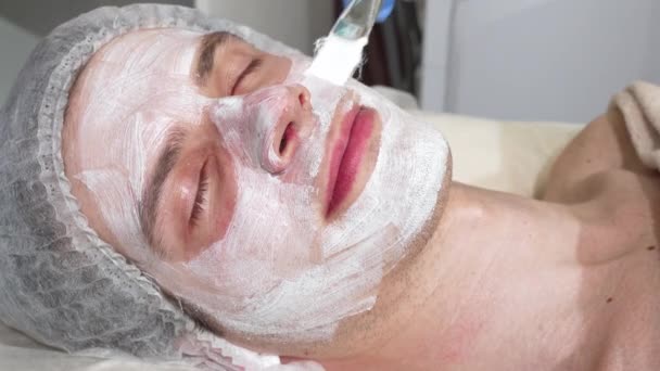 Relaxado homem bonito feliz desfrutando de máscaras faciais no centro de spa — Vídeo de Stock