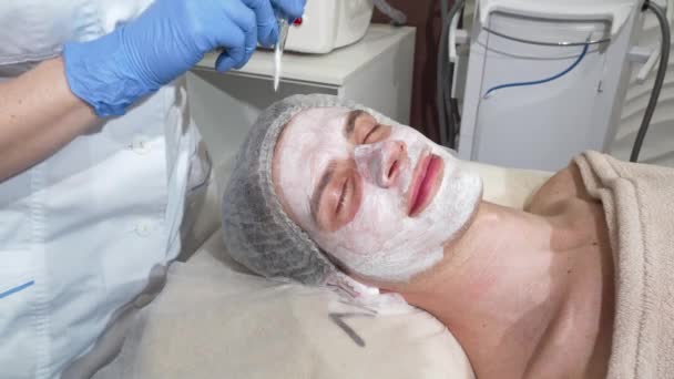 Hombre feliz recibiendo máscaras faciales en el salón de belleza, sonriendo con los ojos cerrados — Vídeo de stock