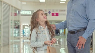 Mutlu küçük kız çocuk mağazası işaret, babası ile alışveriş merkezinde