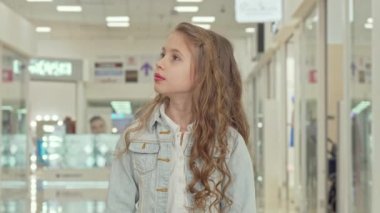 Alışveriş merkezinde kameraya gülümseyen sevimli küçük kız