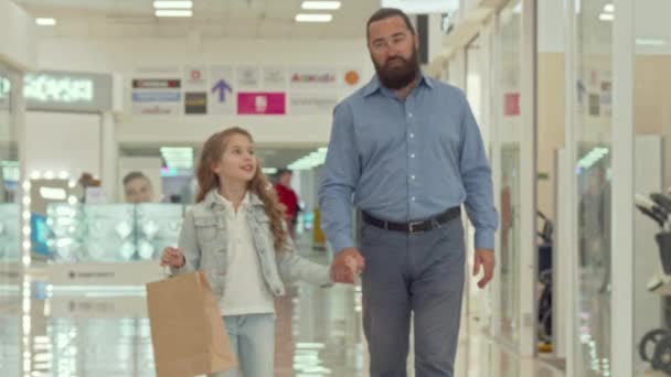 Padre cariñoso caminando en el centro comercial con su adorable hijita — Vídeos de Stock