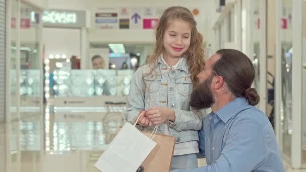 Liten flicka som pekar bort, visar något för sin far på köpcentret — Stockvideo