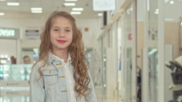 Gelukkig schattig klein meisje toont duimen omhoog in het winkelcentrum — Stockvideo