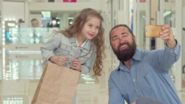 Schattig klein meisje het nemen van selfies met haar vader in het winkelcentrum — Stockvideo