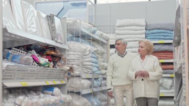 Mutlu emekli yaşlı çift mobilya mağazasında yürüyüş, ev eşyaları için alışveriş