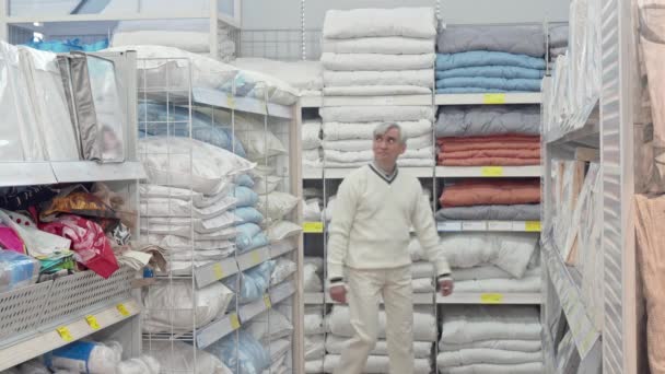 Elderly male customer choosing bedding at home goods store — Stock Video