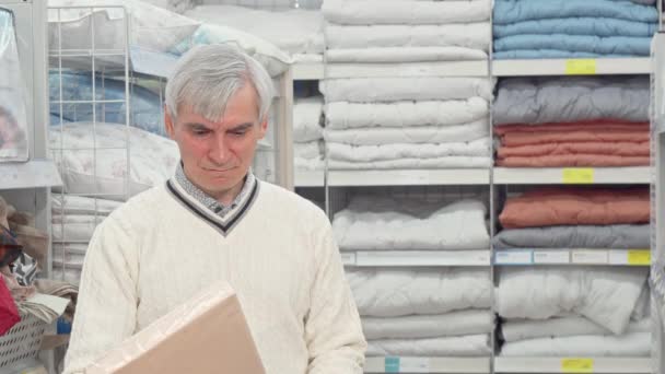 Senior man shopping för sovrummet textil på inredningsbutik — Stockvideo