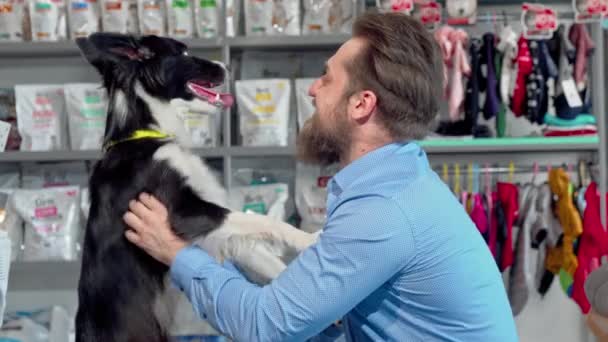 Gelukkig bebaarde man spelen met zijn hond bij dierenarts Office — Stockvideo