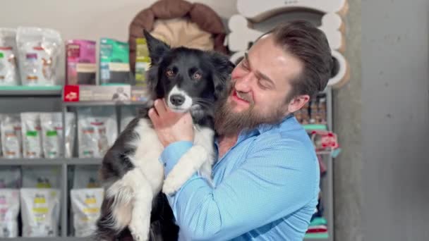Uomo felice che tiene il suo adorabile cane, sorridendo alla macchina fotografica — Video Stock