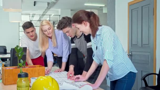 Jóvenes arquitectos trabajando juntos en un proyecto en la oficina — Vídeos de Stock