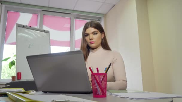 Estudiante cansada frotando templos, trabajando en un portátil — Vídeo de stock