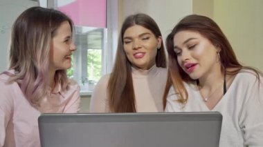 Üç büyüleyici üniversiteli kız birlikte çalışırken gülüyor ve konuşuyor
