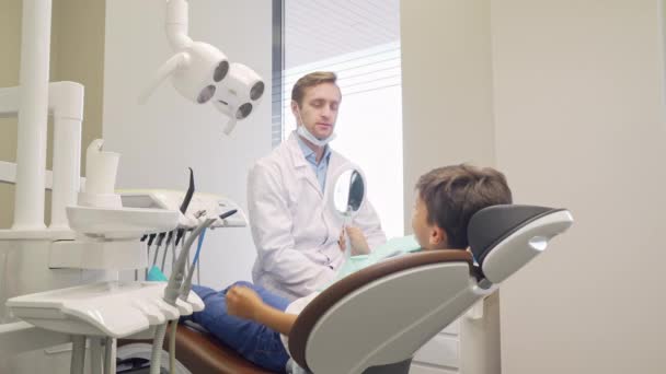 Menino alegre e seu dentista sorrindo para a câmera — Vídeo de Stock