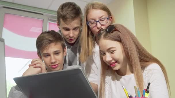 Basso angolo ritagliato colpo di gruppo di adolescenti che studiano insieme, utilizzando il computer portatile — Video Stock