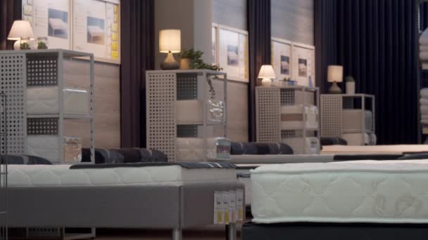 Cliente masculino escolhendo colchão ortopédico e cama na loja de móveis — Vídeo de Stock