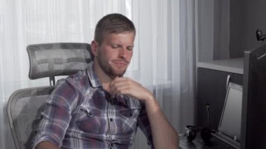 Bilgisayarında bir proje üzerinde çalışırken pizza yiyen adam