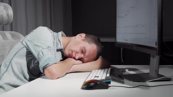 Ο άνθρωπος χαμογελά στον ύπνο του που αναπαύεται στο γραφείο μπροστά από τον υπολογιστή — Αρχείο Βίντεο