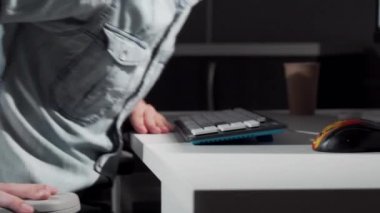 Bilgisayar önünde sandalyesine binen ve işe başlayan bir adamın kırpılmış fotoğrafı