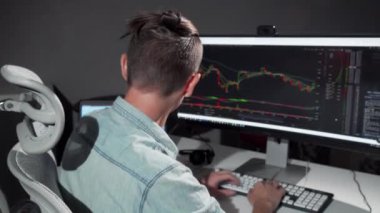 Erkek bilgisayar programcısı ofiste geç saatlere kadar çalışırken kameraya gülümseyen