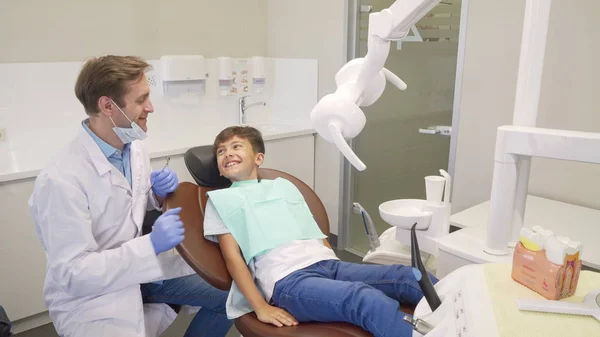 Gelukkige kleine jongen hoge fiving zijn tandarts na succesvolle tandheelkundige onderzoek — Stockfoto