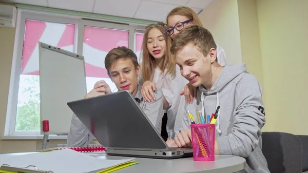 Grupp av tonårs studenter som arbetar på laptop tillsammans — Stockfoto