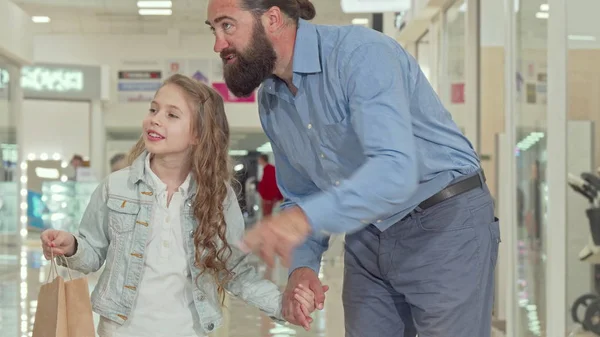 Liefdevolle vader wandelen in winkelcentrum met zijn schattige kleine dochter — Stockfoto